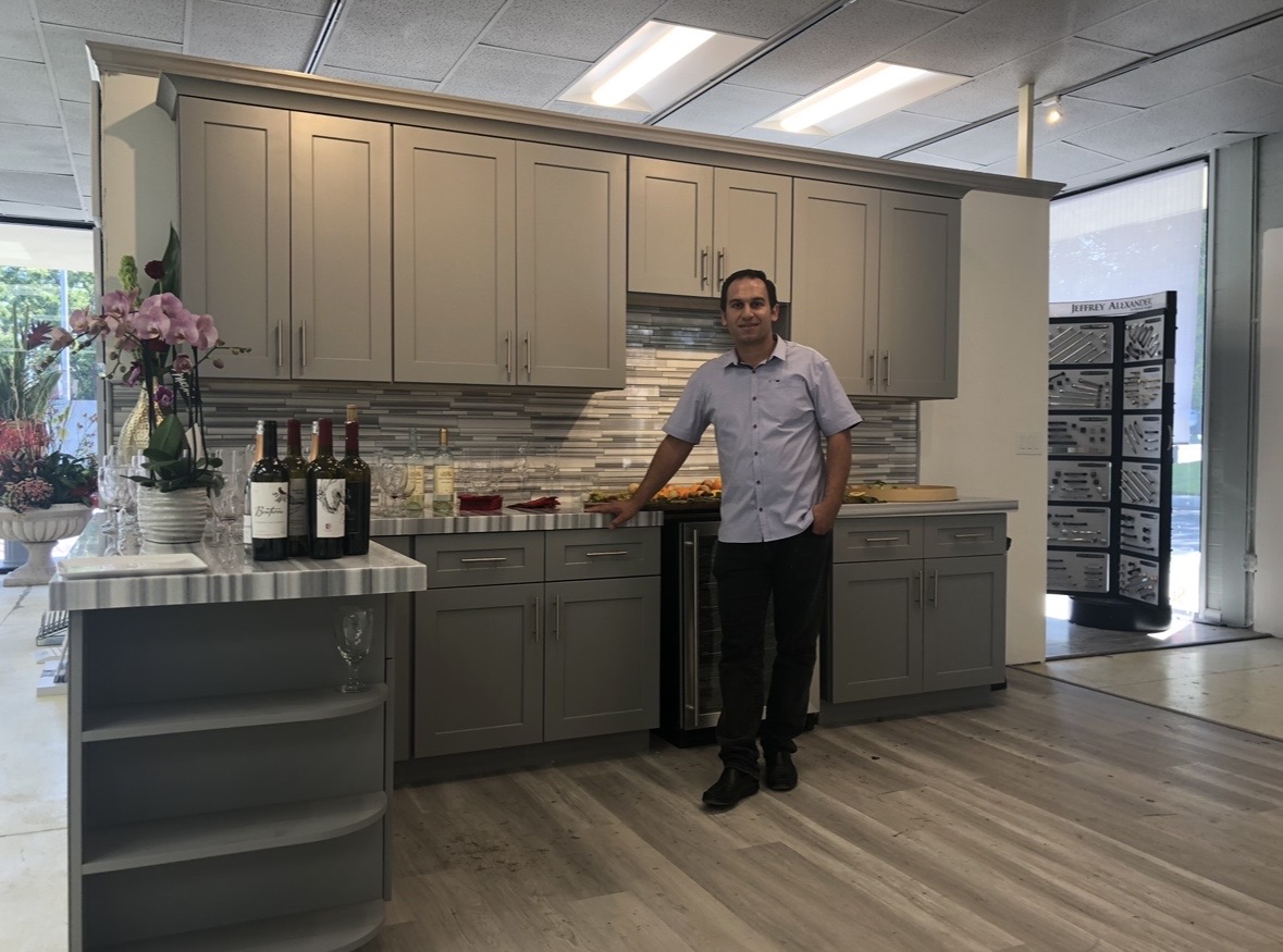 Elbron in a showroom kitchen display with greige shaker cabinets and a marble island