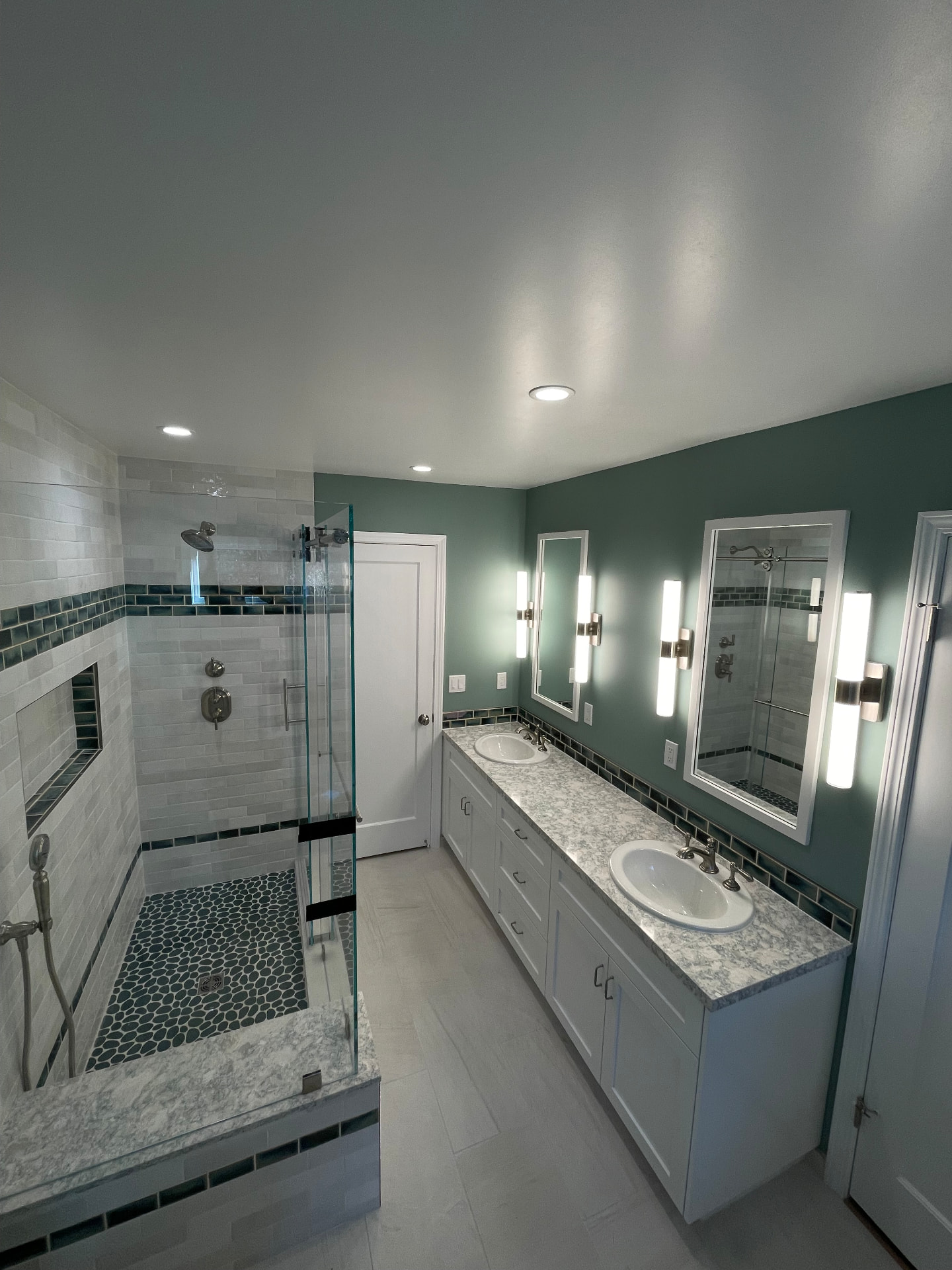 Full bathroom remodel with tiled walk-in shower and double vanity