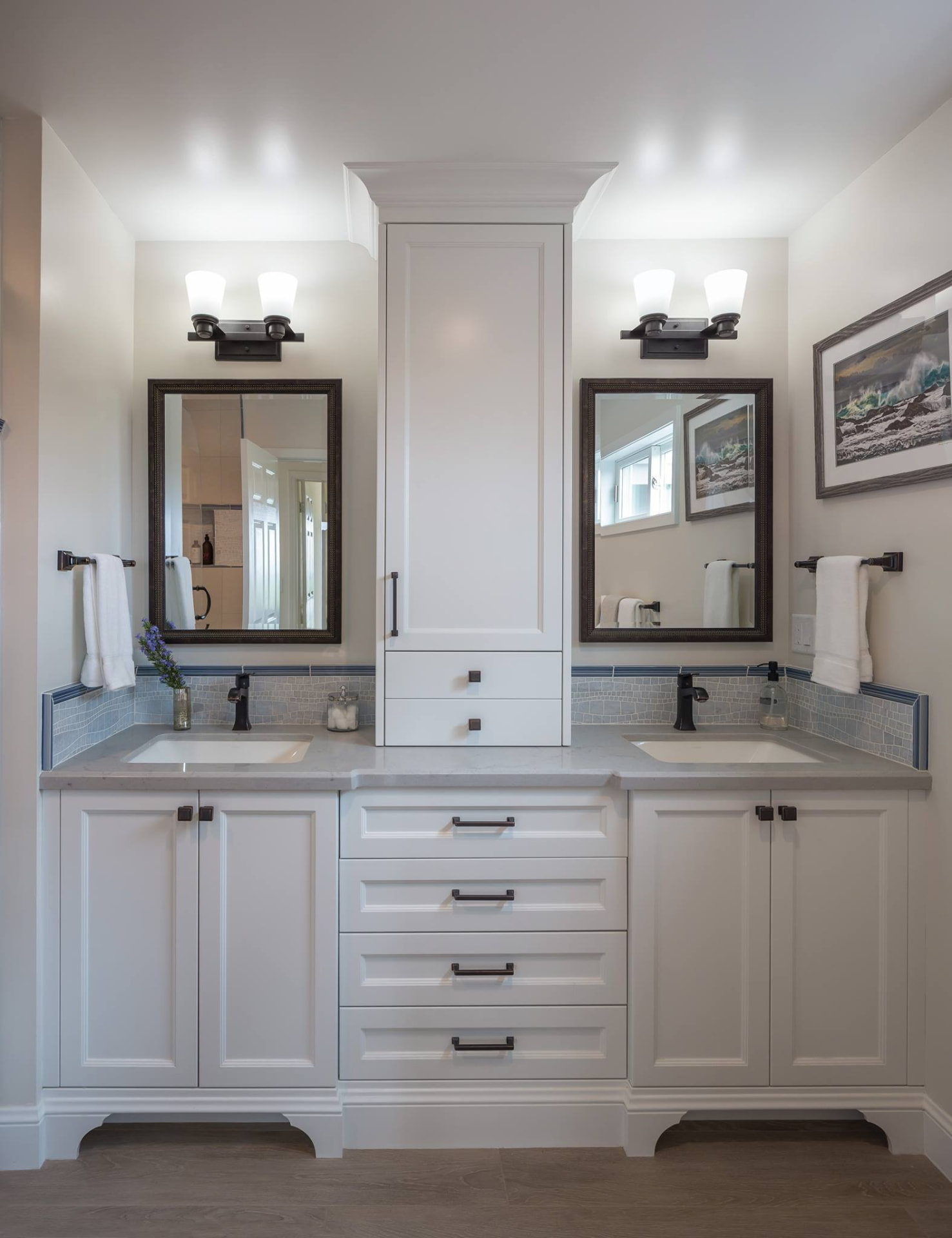 White double vanity with center linen tower and tile backsplash